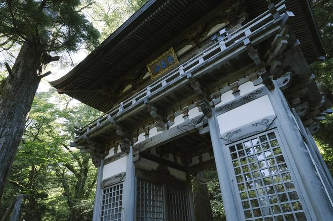 山の麓に立つ重厚な木造の寺院の山門